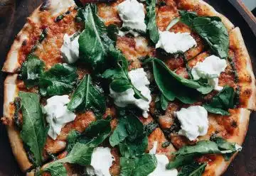 pizza with green leaves on top